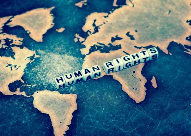 A blue and yellow portion of a world map, with the words "Human Rights" written in dice placed on top of the map.